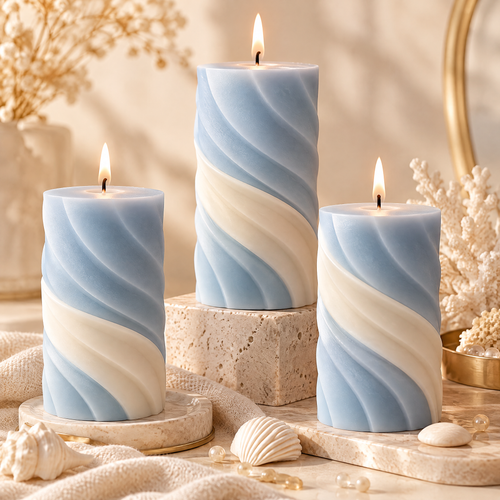 KAELIROAY® Ocean Swirl Pillar Candle Set — 3 candles lit in sky blue and ivory spiral design, displayed on marble trays with seashells and coral decor